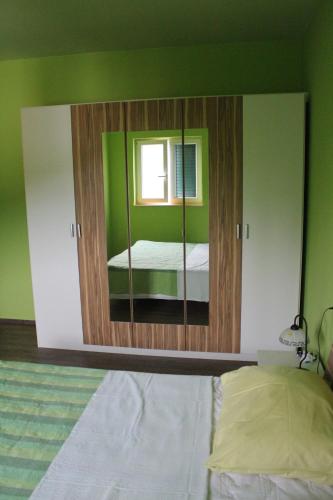 a bedroom with a mirror with a bed in it at Primavera in Omišalj