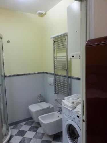 a bathroom with a toilet sink and a washing machine at Smiths & Herreros in Genova