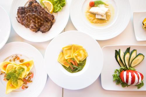 a group of white plates of food on a table at The Florence Hills Resort & Wellness in Pelago