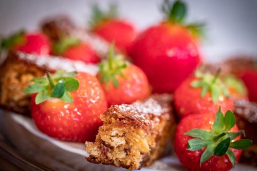 a plate of strawberries with a piece of cake at Seaside Hideaway in Scarborough