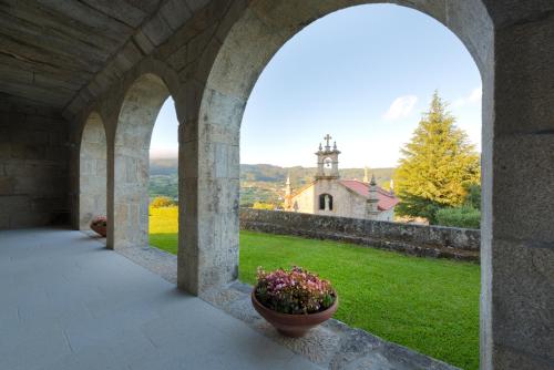 an archway with a flower pot in front of a church at Torre de Tebra in Tomiño