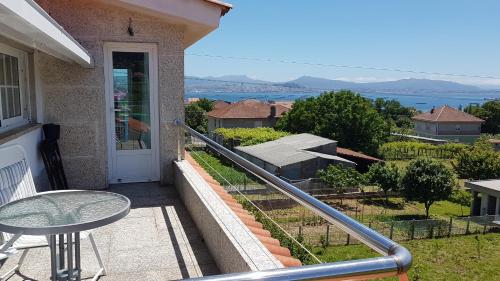 a balcony with a table and a view of the water at Apartamento con estupendas vistas in Moaña