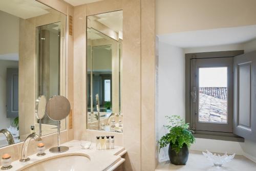 a bathroom with a sink and a large mirror at Château Lafaurie-Peyraguey Hôtel & Restaurant LALIQUE in Bommes