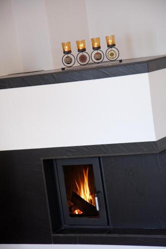 a fireplace with a fire inside of it at Ferienhaus Alex in Wiesing