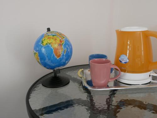 a glass table with a globe and a coffee mug at Salve комнаты и апартаменты in Odesa