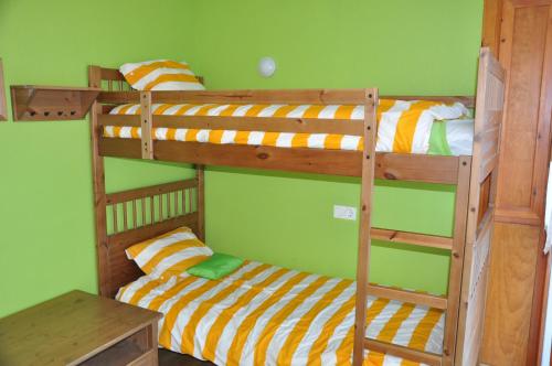 イサバにあるApartamento en Isaba (NAVARRA)の緑の壁のドミトリールームの二段ベッド2台