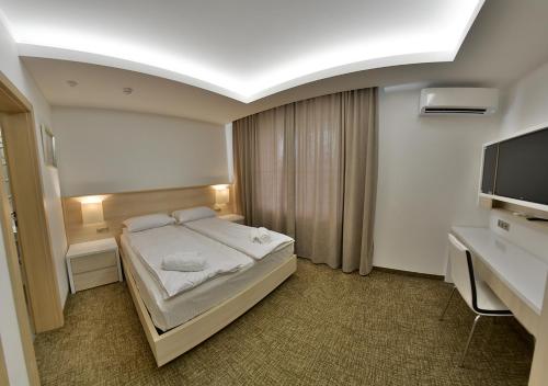 a hotel room with a bed and a television at Apartment OneClickRent_04 - Smart House in Chişinău