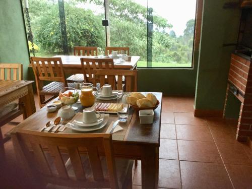 uma mesa de madeira com comida para o pequeno almoço em cima em Abrigo da Reserva em Santo Antônio do Pinhal