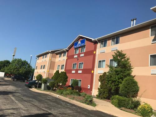 a building with a sign on it next to a street at Americas Best Value Inn and Suites Saint Charles in St. Charles