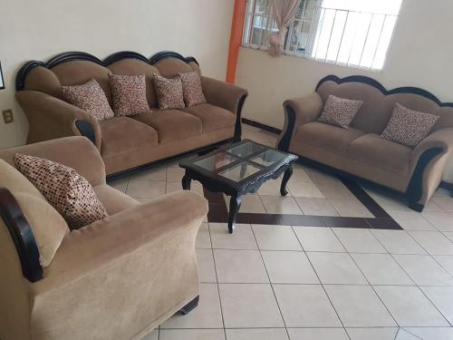 a living room with two couches and a coffee table at Hotel Maria Elena in Ciudad Madero