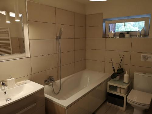 a bathroom with a tub and a sink and a toilet at Ubytovanie v súkromí na Liptove in Liptovský Ján