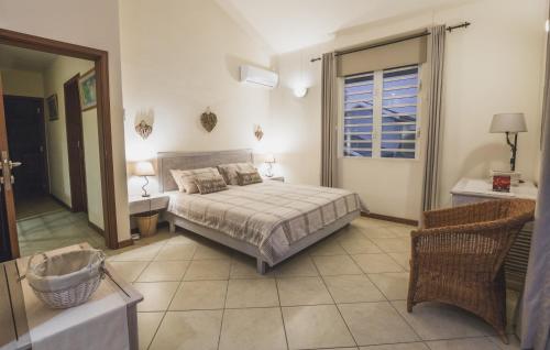 a bedroom with a bed and a bathroom at Villa Bayswater in Tamarin