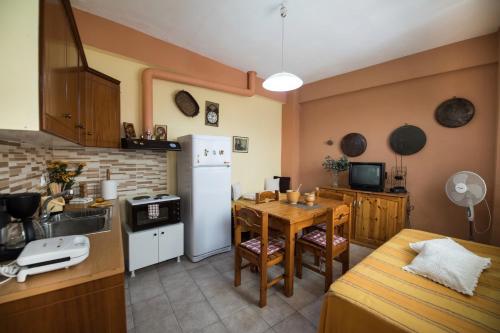 a kitchen with a table and a refrigerator at Manthiata Studios in Exanthia