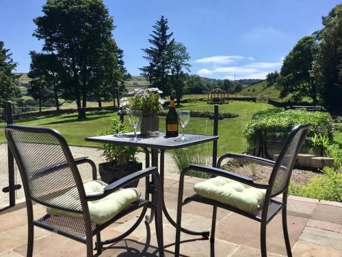 a table with two chairs and a bottle of wine at Room with a View in Holmfirth