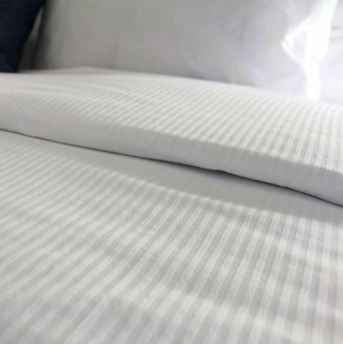 a close up of a bed with a white sheet at Quality Inn Mont-Laurier in Mont-Laurier