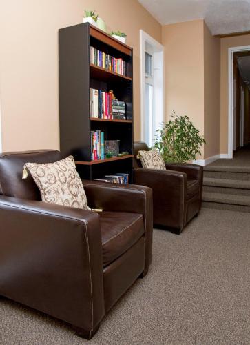 two brown leather chairs and a book shelf with books at Hotel Squamish in Squamish