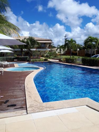 a swimming pool with blue water in a resort at Vila das Flores ( vilage) in Itacimirim