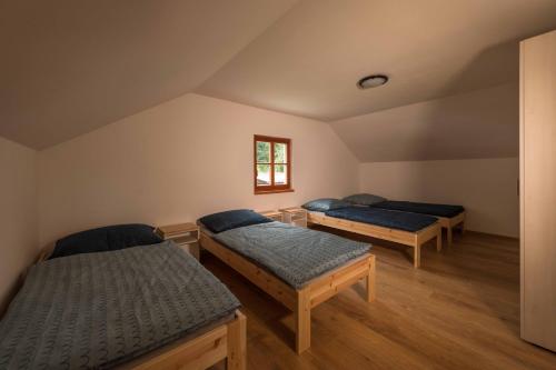 a room with three beds and a window at Chaty a Apartmány Hracholusky Kemp Kosatka in Pňovany