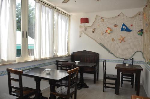 un comedor con mesas y sillas y un mapa en la pared en Il Grifo, en Sabaudia