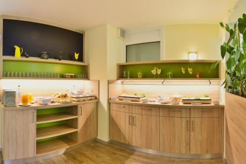 a kitchen with wooden cabinets with food on them at Garden Hotel in Nuremberg