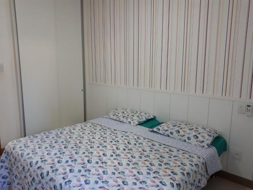 a small bedroom with a bed and two pillows at Vila das Flores ( vilage) in Itacimirim