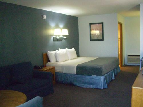 Säng eller sängar i ett rum på Quail's Nest Inn & Suites