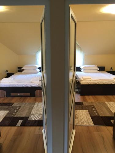 two beds in a room with two mirrors at Casa Roman in Vişeu de Sus