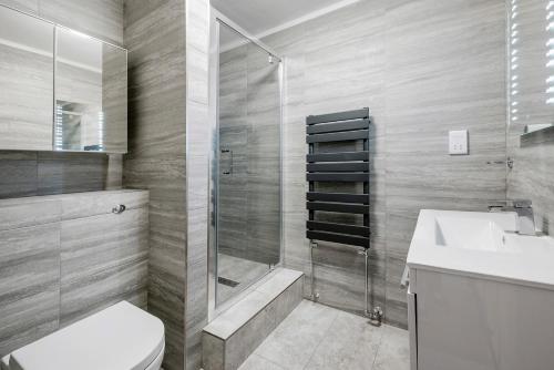 a bathroom with a shower and a toilet and a sink at Prime London Apartment, Oxford Circus in London
