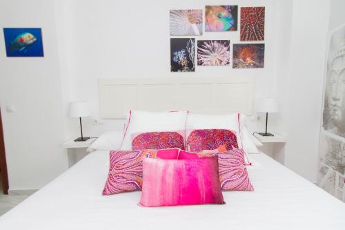 マラガにあるGood Vibes Estudio Deluxe Trinidad 2の白いベッド(ピンクの枕2つ付)