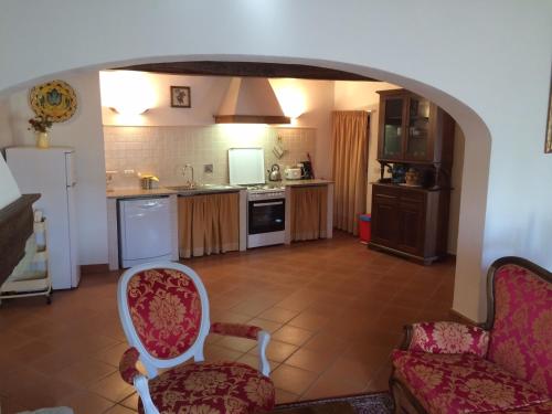 a kitchen with an archway and two chairs in a room at Casa Vacanze Villa il Castellaccio in Lucolena in Chianti
