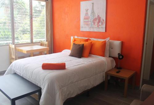 um quarto com uma cama grande e uma parede laranja em Super Ubicacion em Guatemala