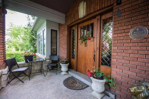 a porch of a house with chairs and a door at Avonview Manor in Stratford