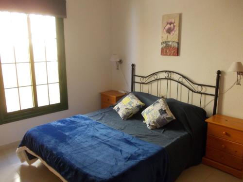 a bedroom with a bed with blue sheets and two pillows at Caleta Paraiso - Lovely Coastal Apartment in Costa de Antigua