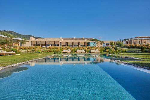 a large pool of blue water in front of a building at Pleta de Mar, Grand Luxury Hotel by Nature - Adults Only in Canyamel
