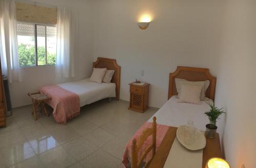サンルーカル・デ・バラメダにあるCasa Algaidaのベッドルーム1室(ベッド2台、テーブル、窓付)