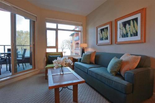 a living room with a blue couch and a table at Watermark Beach Resort in Osoyoos