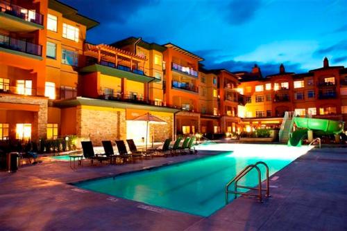 a swimming pool in front of a building at night at Watermark Beach Resort in Osoyoos