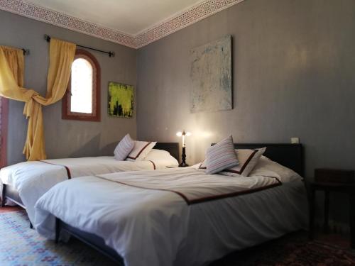 two beds sitting in a room with a window at Villa du Souss in Agadir