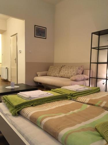 sala de estar con 2 camas y sofá en Arany Janos Apartman, en Budapest