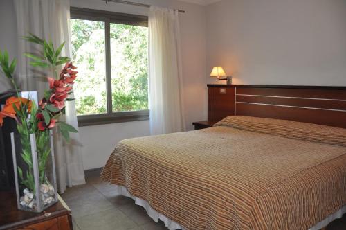 a hotel room with a bed and a window at Hotel Savoia Mendoza in Guaymallen