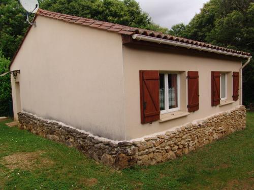 ein kleines Haus mit einer Steinmauer in der Unterkunft Les Petits Prés in Vitrac