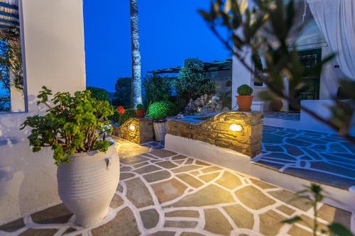 a patio with a large vase with plants in it at Fouli's House at "Porto Vlastos" in Agios Ioannis Tinos