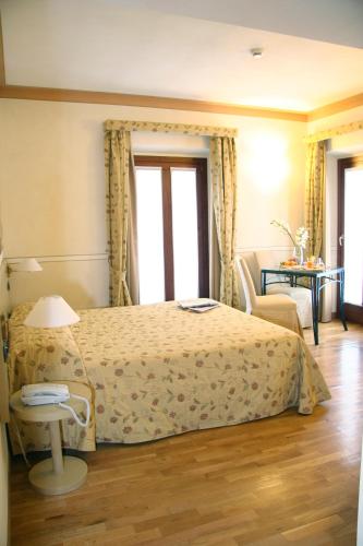 a bedroom with a bed and a table and a chair at Villa Bregana in Carnago