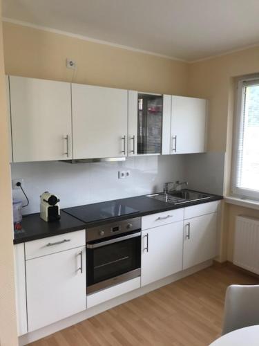 a kitchen with white cabinets and a sink at Waarkstrooss 12 in Welscheid