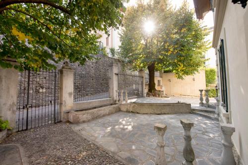 an empty courtyard with a fence and a tree at Villa Puccini Bed & Breakfast in Lecco