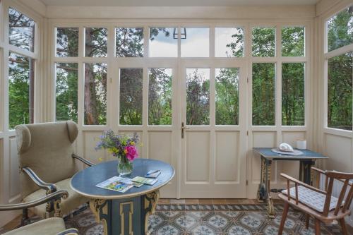 a room with windows and a table and chairs at Villa Tranquillini auf Gut Guntrams in Schwarzau am Steinfelde