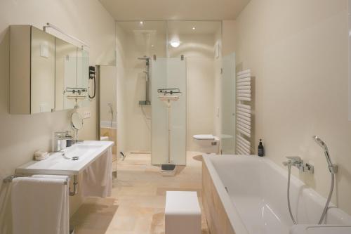 a bathroom with a tub and a toilet and a sink at Villa Tranquillini auf Gut Guntrams in Schwarzau am Steinfelde