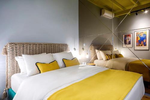 a bedroom with a large white bed with yellow pillows at The Frogs_Guest House in Athens