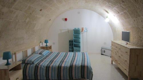 casa vacanza Regina في غروتاليي: غرفة نوم بسرير وتلفزيون في نفق