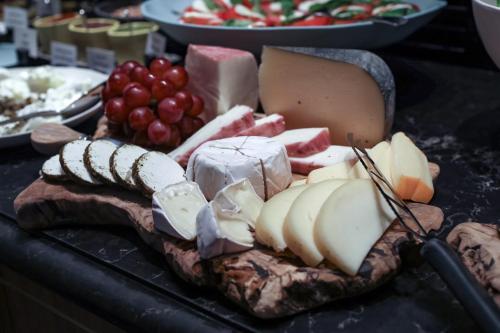 a tray of cheese and meats on a table at Melody Hotel - an Atlas Boutique Hotel in Tel Aviv